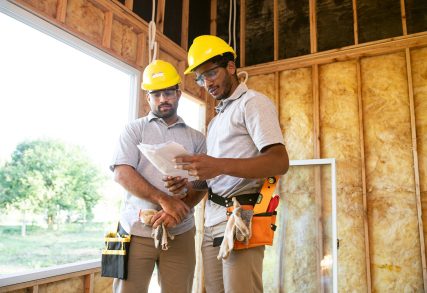 Builders discussing project plans at site